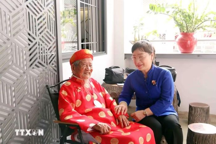 Bà Thái Thị Hồng Nga, Bí thư Đảng ủy, Chủ tịch HĐND phường Bình Lợi Trung chào đón cụ Nguyễn Đình Tư về sinh sống tại phường Bình Lợi Trung. (Ảnh: Xuân Khu/TTXVN)