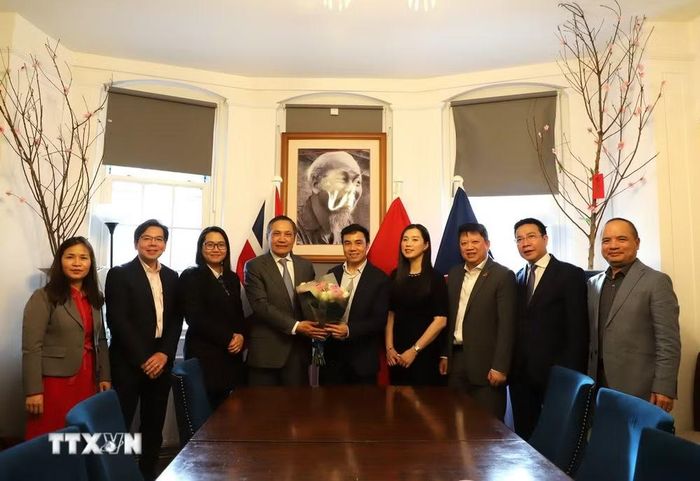 Đại sứ Đỗ Minh Hùng và các cán bộ Đại sứ quán Việt Nam tại Anh chụp ảnh lưu niệm với Ban chấp hành Hội Trí thức Việt Nam tại Anh và Ireland (VIS). (Ảnh: Hữu Tiến/TTXVN)
