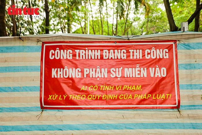 Biển cảnh báo công trình đang thi công được đặt tại khu vực rào chắn trong công viên, bảo đảm an toàn cho người dân.