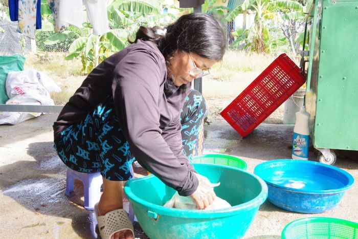 Chị Phan Thanh Chi rửa sạch thực phẩm cho bữa ăn. Ảnh: Huy Tứ