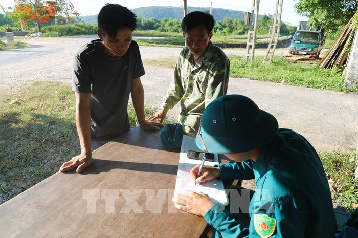 Lực lượng thực hiện nhiệm vụ tại chốt canh cửa rừng ghi chép thông tin liên quan đến người, phương tiện ra, vào rừng. Ảnh: Xuân Tiến - TTXVN