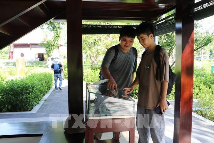 Du khách tìm hiểu hiện vật tại Nhà sàn Bác Hồ. Ảnh: Hồng Thái - TTXVN