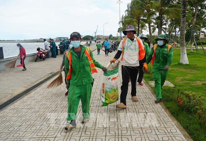 Các đại biểu ra quân thực hiện quét dọn, thu gom rác thải tại khu vực bờ biển, công viên Tôn Đức Thắng trên địa bàn phường. Lê Huy Hải - TTXVN