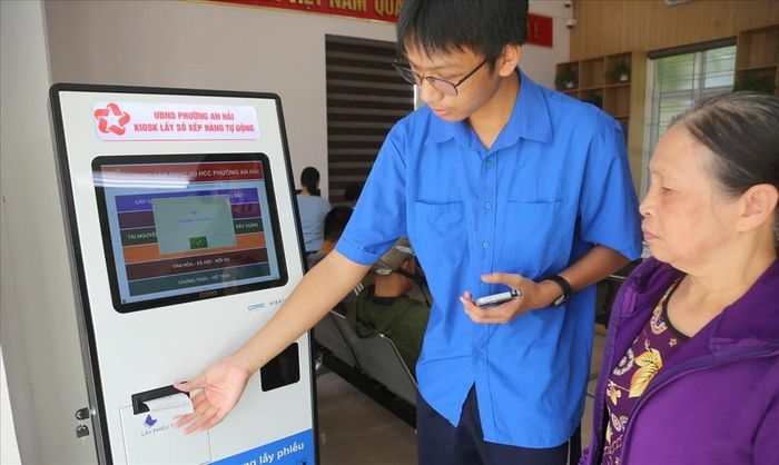 Thanh niên hỗ trợ người dân lấy phiếu thực hiện dịch vụ công tại UBND phường An Hải, Hải Phòng. Ảnh: Minh Thu - TTXVN
