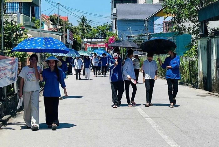 Đoàn thanh niên phường Ngọc Sơn hỗ trợ che nắng cho thí sinh đến địa điểm thi.