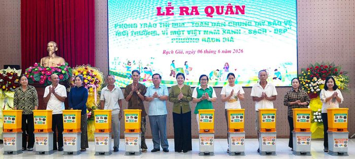Thường trực Đảng ủy phường Rạch Giá trao tặng dụng chứa và phân loại rác thải cho hộ dân.