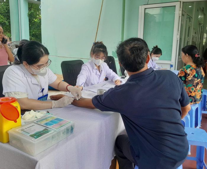 Nhân viên y tế tiến hành lấy mẫu máu của người dân để tiến hành xét nghiệm. Ảnh: LÊ HÙNG