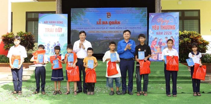 Bí thư Thành đoàn Lê Công Hùng (thứ 4, phải sang) và Phó Bí thư Đảng ủy UBND thành phố Nguyễn Xuân Đức (thứ 5, trái sang) tặng quà cho thiếu nhi vượt khó học tốt. Ảnh: THU HƯƠNG