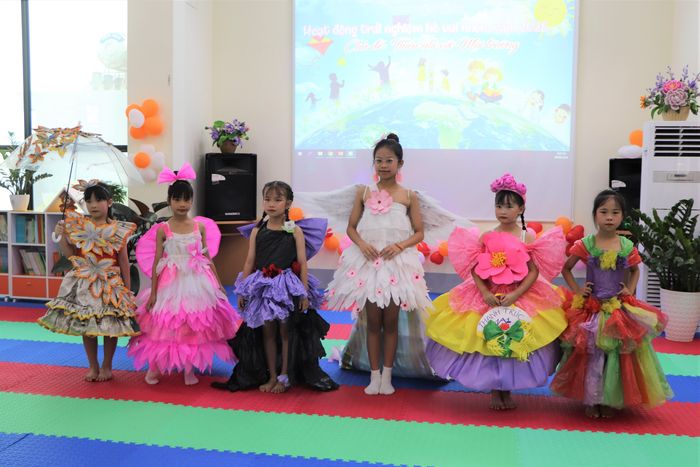 Thiếu nhi trình diễn thời trang với các mẫu trang phục từ rác thải tái chế. 