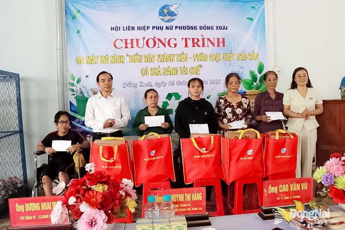 Ủy ban MTTQ Việt Nam phường Đồng Xoài tặng quà cho các hộ khó khăn, nhân dịp ra mắt mô hình “Biến rác thải thành tiền - Phân loại rác thải rắn có khả năng tái chế”. Ảnh: Quang Minh
