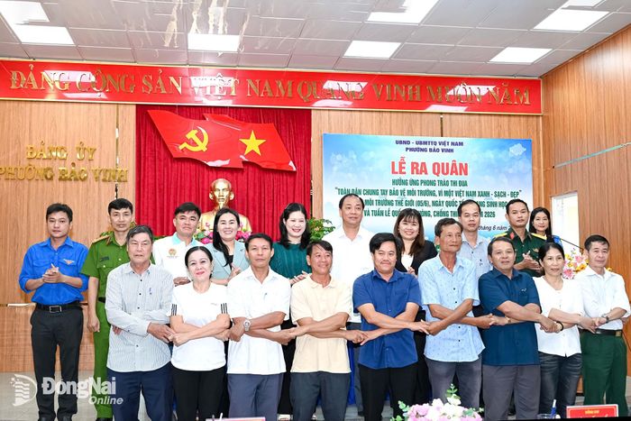 Đại diện các cơ quan, đơn vị và Ban điều hành 10 khu phố trên địa bàn phường bắt tay quyết tâm thực hiện tốt phong trào thi đua. Ảnh: Hương Lan