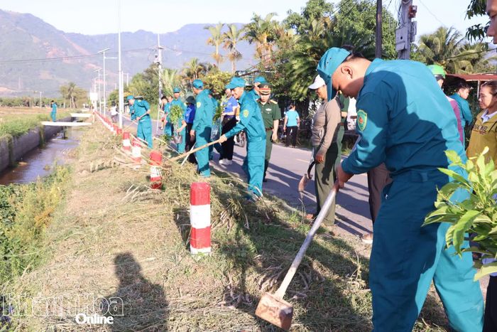 Lực lượng dân quân xã Suối Dầu cùng người dân tham gia làm sạch tuyến đường và trồng cây xanh.
