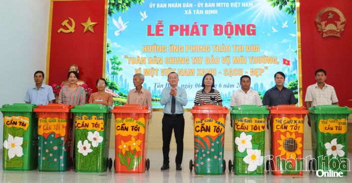 Lãnh đạo Đảng ủy xã trao thùng rác nhựa cho các khu dân cư.