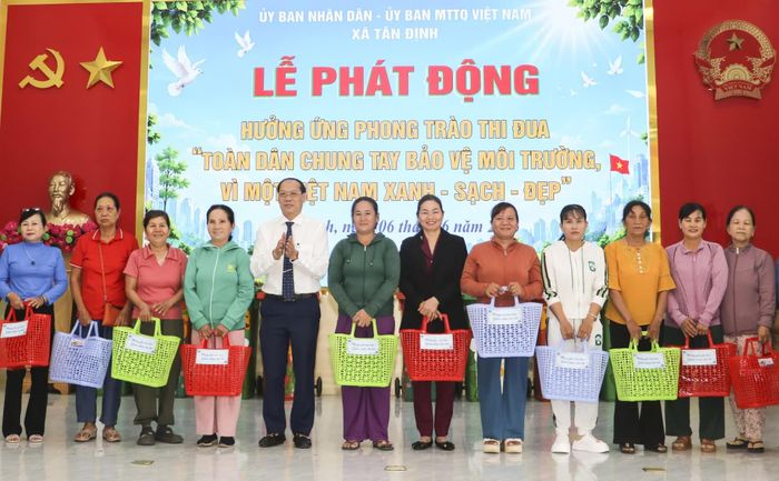 Lãnh đạo UBND xã Tân Định trao giỏ xách cho các hộ gia đình.
