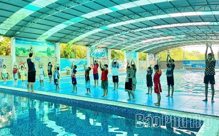 Các em thiếu nhi được hướng dẫn khởi động trước khi xuống bơi.