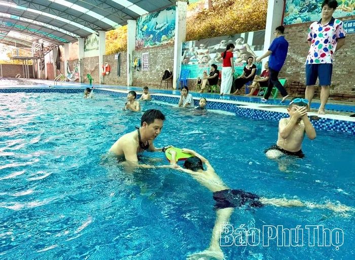 Huấn luyện viên hướng dẫn kỹ các em kỹ thuật bơi ếch.