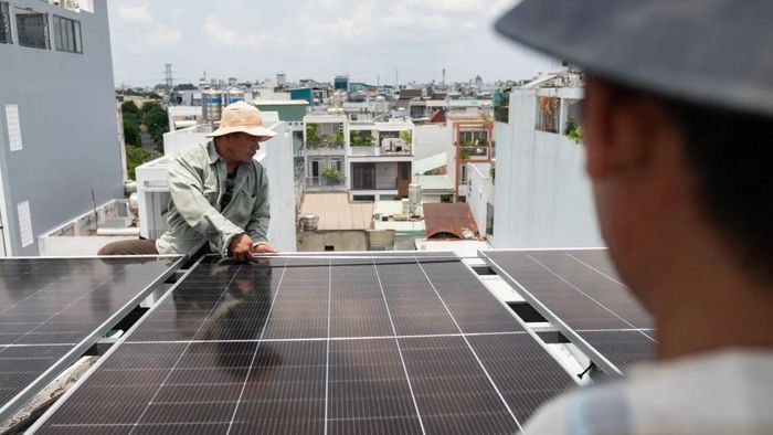 Công nhân lắp đặt tấm pin năng lượng mặt trời trên mái nhà của một ngôi nhà tại Thành phố Hồ Chí Minh. Việc lắp đặt điện mặt trời trên mái nhà như một phần của nỗ lực rộng lớn hơn hướng tới năng lượng tái tạo và an ninh năng lượng dài hạn. Ảnh: Getty.