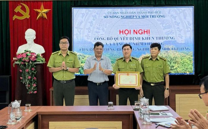 Đồng chí Lê Văn Anh - Phó Giám đốc phụ trách Sở Nông nghiệp và Môi trường Tp. Huế trao tặng Bằng khen cho tập thể Chi cục Kiểm lâm thành phố