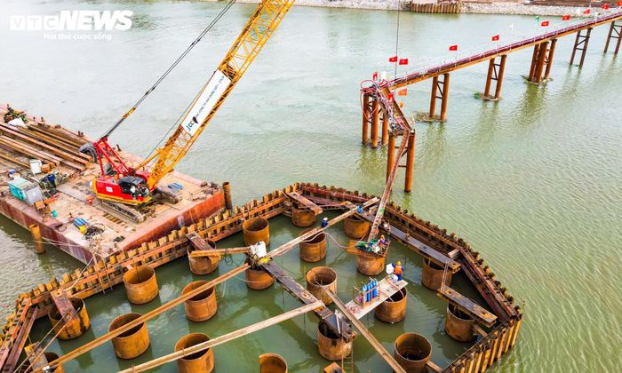 Trên sông Hồng, nhiều trụ cầu đã bắt đầu hình thành. Sau khi hoàn thành phần lớn công tác thi công nền móng, dự án đang chuyển dần sang giai đoạn xây dựng đài móng và thân trụ.