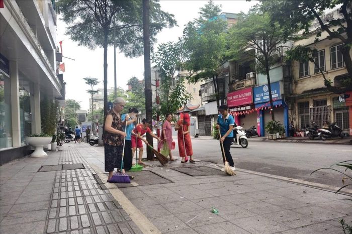 Hội viên phụ nữ tham gia vệ sinh môi trường sáng 6-6. Ảnh: An Quyên