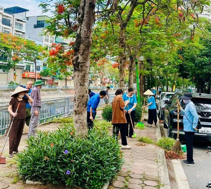 Các lực lượng quét dọn, làm sạch đẹp vỉa hè dọc bờ sông Sét. Ảnh: HM