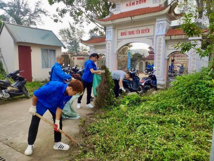 Đoàn viên, thanh niên dọn cỏ ở khu vực trong và ngoài Nghĩa trang Yên Duyên. Ảnh: HM