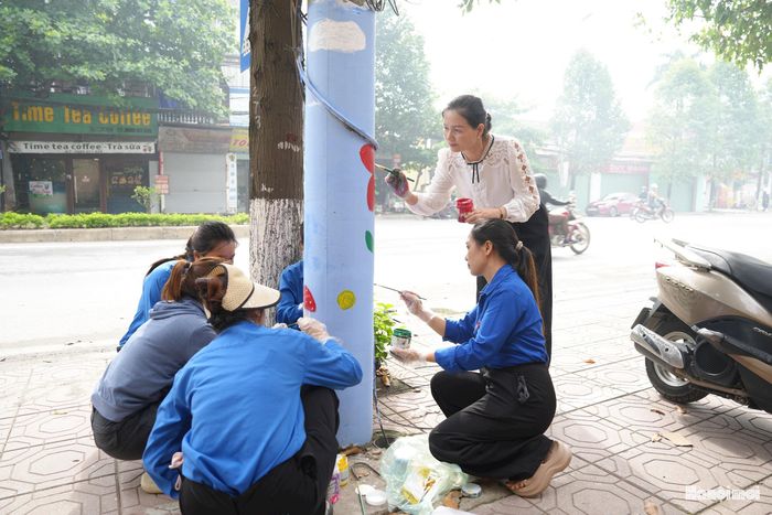 Lãnh đạo MTTQ Việt Nam xã Thanh Oai và đoàn viên thanh niên vẽ tranh tại các cột điện. Ảnh: Mai Quý