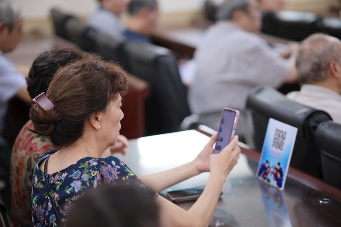 Người dân quét mã QR để tải tài liệu học tập.
