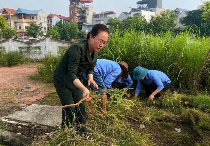 Phó Bí thư Thường trực Đảng ủy phường Tây Tựu Nguyễn Thị Nắng Mai cùng nhân dân tham gia vệ sinh môi trường sau lễ phát động hưởng ứng. Ảnh TT