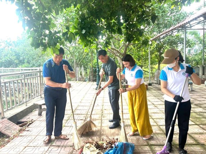Chủ tịch UBND xã Nguyễn Quý Mạnh cùng cán bộ xã vệ sinh môi trường. Ảnh: Hội Phụ nữ xã