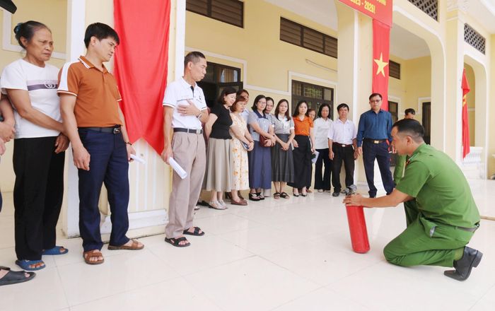 Công an xã Tây Phương hướng dẫn mọi người cách sử dụng bình chữa cháy. Ảnh: Công Phương