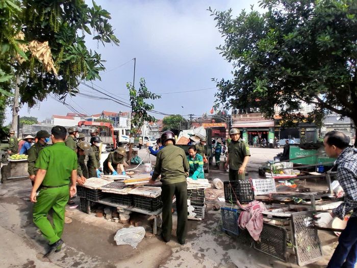 Lực lượng chức năng tháo dỡ dọn dẹp khu chợ tự phát gây ô nhiễm môi trường và gây mất trật tự ở thôn Bảo Lộc. Ảnh: Nguyễn Hưng