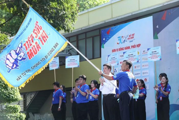 Anh Lâm Tùng - Ủy viên Ban chấp hành Trung ương Đoàn, Phó chủ tịch Thường trực Trung ương Hội Sinh viên Việt Nam và anh Lê Nguyễn Nam - Trưởng ban tổ chức chương trình Tiếp sức mùa thi năm 2026 thực hiện nghi thức trao cờ. Ảnh: Tiếp sức mùa thi - TP.HCM