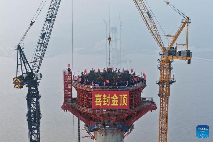  Cầu dài tổng cộng 3.118 m, trong đó nhịp chính dài 1.488 m. Hiện tại, đây là cầu công - thiết có nhịp lớn nhất thế giới. Thay vì tách thành hai cầu riêng, công trình được thiết kế theo mô hình đường sắt và đường bộ cùng nằm trên một hành lang kết cấu. Cách bố trí này đã đẩy bề rộng mặt cầu lên tới 68 m, khiến dự án được truyền thông Trung Quốc mô tả là cầu vượt biển rộng nhất thế giới trong nhóm cầu công - thiết lưỡng dụng. Ảnh: Xinhua. 
