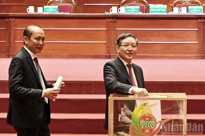 Chủ tịch Hội Nông dân Việt Nam khóa VIII Lương Quốc Đoàn (bên phải) bỏ phiếu tại phiên làm việc.