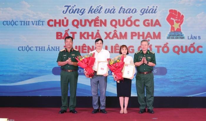 Tác giả Nguyễn Thị Ngọc Thùy, đoạt giải ba cuộc thi viết với tác phẩm “Trường Sa nơi anh nằm lại” và tác giả Nguyễn Trung Trực, đoạt giải ba cuộc thi ảnh với bộ ảnh “Tổ quốc và người lính biển”. Ảnh: HOÀNG TRIỀU