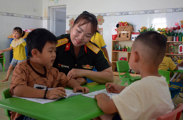 Thiếu tá QNCN Roãn Thị Ngọc Hảo hướng dẫn các bé tập làm quen với chữ cái.