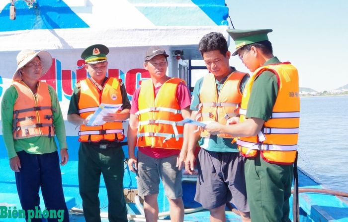 Cán bộ Đồn Biên phòng Phước Tỉnh tuyên truyền, hướng dẫn ngư dân về các giải pháp phòng, chống thiên tai, tai nạn trên biển. Ảnh: Văn Danh