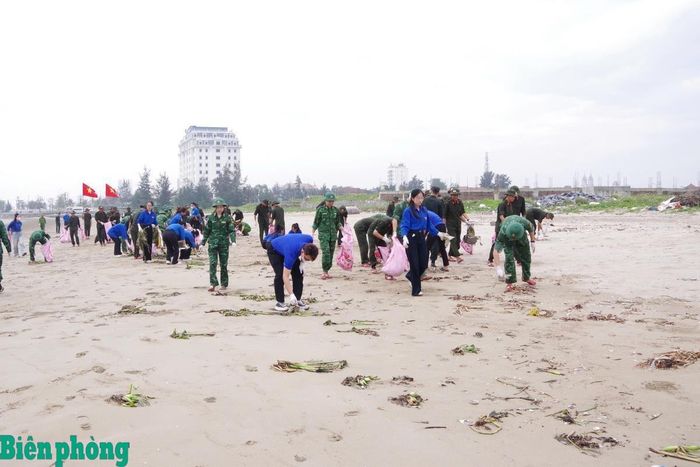 Cán bộ, chiến sĩ Bộ đội Biên phòng tỉnh Nghệ An phối hợp với đoàn viên, thanh niên địa phương thu gom rác thải, làm sạch bãi biển. Ảnh: Hải Thượng