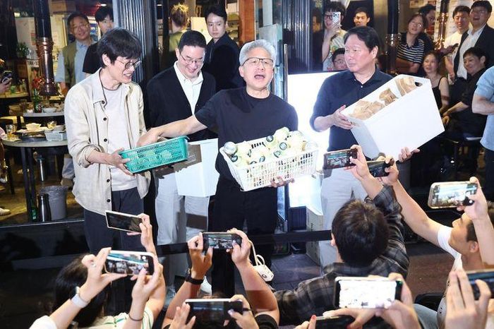 Các lãnh đạo công nghệ phát quà cho những người hâm mộ theo dõi bên ngoài. Ảnh: Yonhap