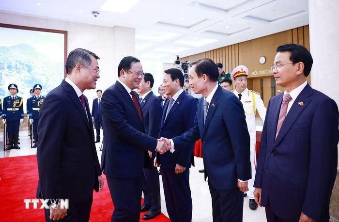 Thủ tướng Lê Minh Hưng giới thiệu với Thủ tướng Lào Sonexay Siphandone thành viên đoàn Việt Nam tham dự lễ đón. (Ảnh: Dương Giang/TTXVN)