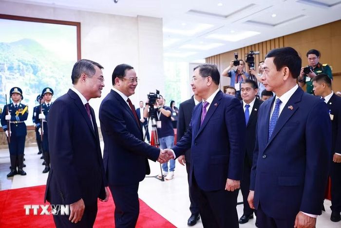 Thủ tướng Lê Minh Hưng giới thiệu với Thủ tướng Lào Sonexay Siphandone thành viên đoàn Việt Nam tham dự lễ đón. (Ảnh: Dương Giang/TTXVN)