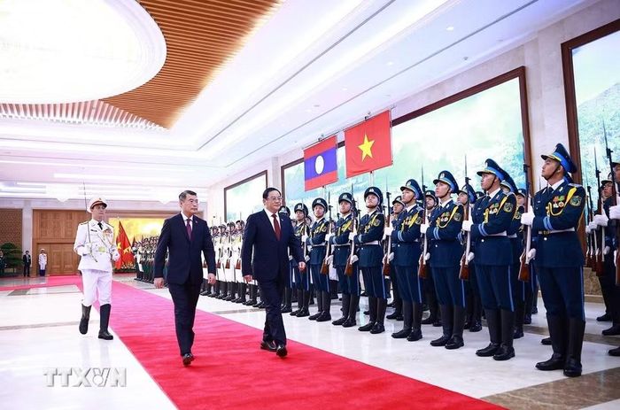 Thủ tướng Lê Minh Hưng và Thủ tướng Lào Sonexay Siphandone duyệt Đội danh dự Quân đội nhân dân Việt Nam. (Ảnh: Dương Giang/TTXVN)