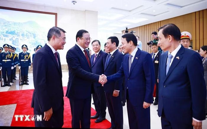 Thủ tướng Lê Minh Hưng giới thiệu với Thủ tướng Lào Sonexay Siphandone thành viên đoàn Việt Nam tham dự lễ đón. (Ảnh: Dương Giang/TTXVN)