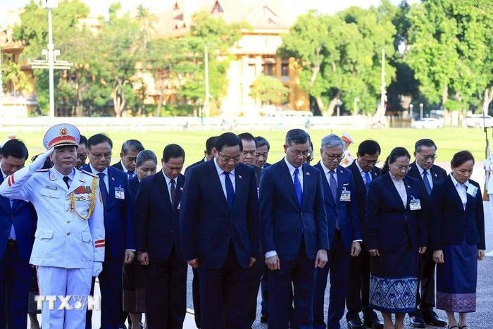 Thủ tướng Lào Sonexay Siphandone và các đại biểu kính cẩn tưởng niệm Chủ tịch Hồ Chí Minh. (Ảnh: Tuấn Anh/TTXVN)