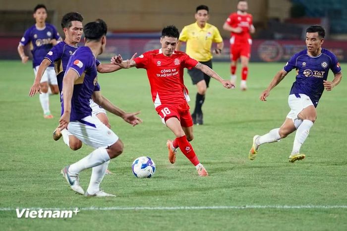 Bùi Ngọc Long đi bóng giữa vòng vây các cầu thủ Hà Nội FC. (Ảnh: Việt Anh/Vietnam+)