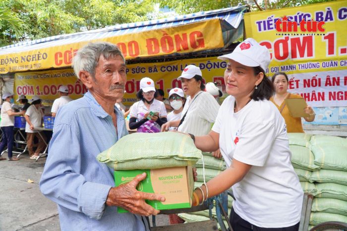 Ông Bảy nhận phần quà do mạnh thường quân trao tặng tại quán cơm 1.000 đồng.