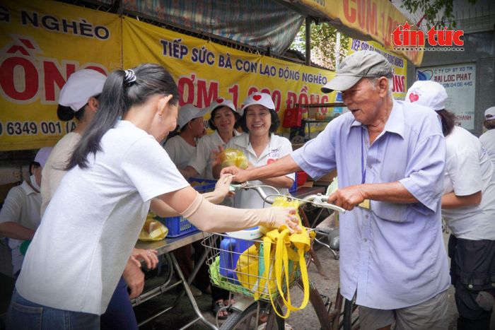 Các tình nguyện viên vui vẻ trò chuyện với người dân đến mua cơm tại quán cơm 1.000 đồng.