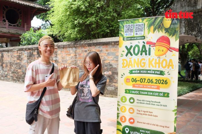 Hai sĩ tử nhận “xoài Đăng khoa” cầu may mắn tại khuôn viên Văn Miếu.