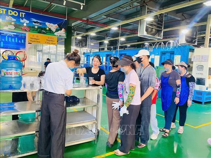 Bên cạnh hệ thống quạt làm mát được duy trì thường xuyên, doanh nghiệp còn tăng cường bổ sung nước uống giải nhiệt phục vụ công nhân trong suốt ca làm việc. Ảnh: Khiếu Tư/TTXVN